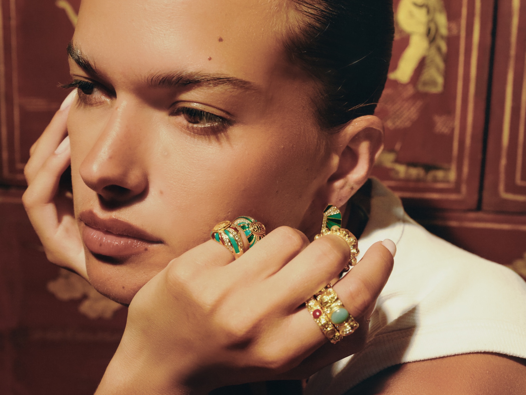 Hand at cheek with stacked rings